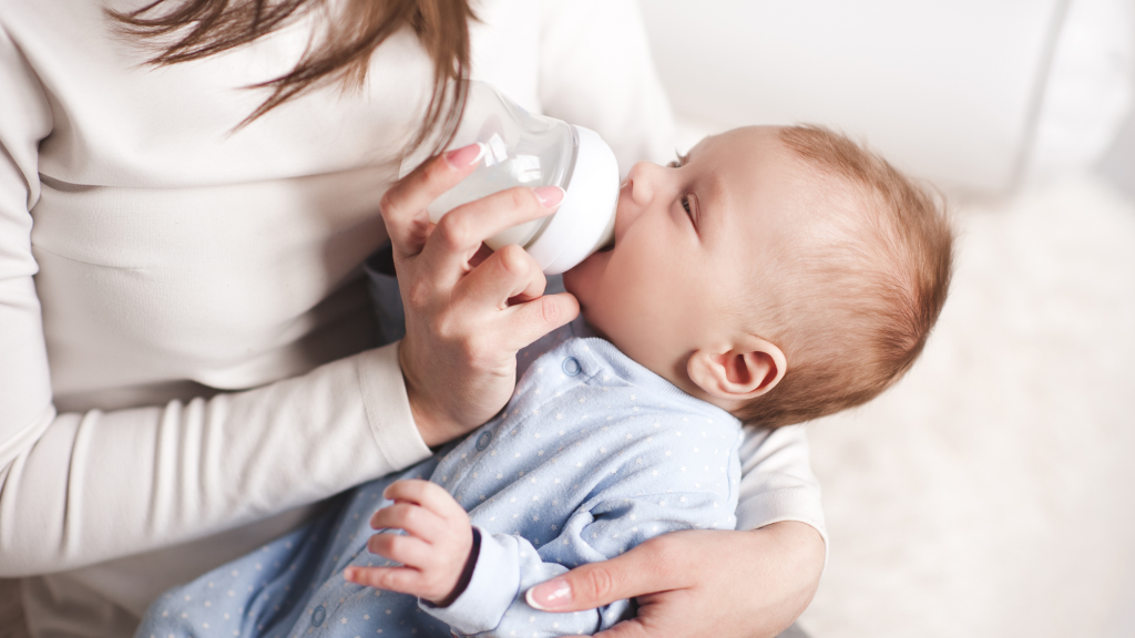 mom who is bottle feeding baby using kaizos tip to avoid neck and upper back pain
